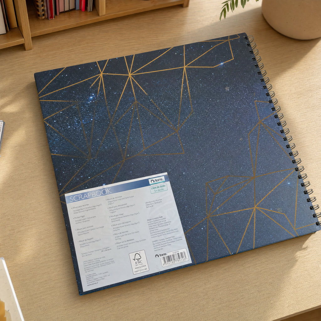 Álbum encuadernado en espiral azul oscuro con líneas geométricas doradas y puntos estelares