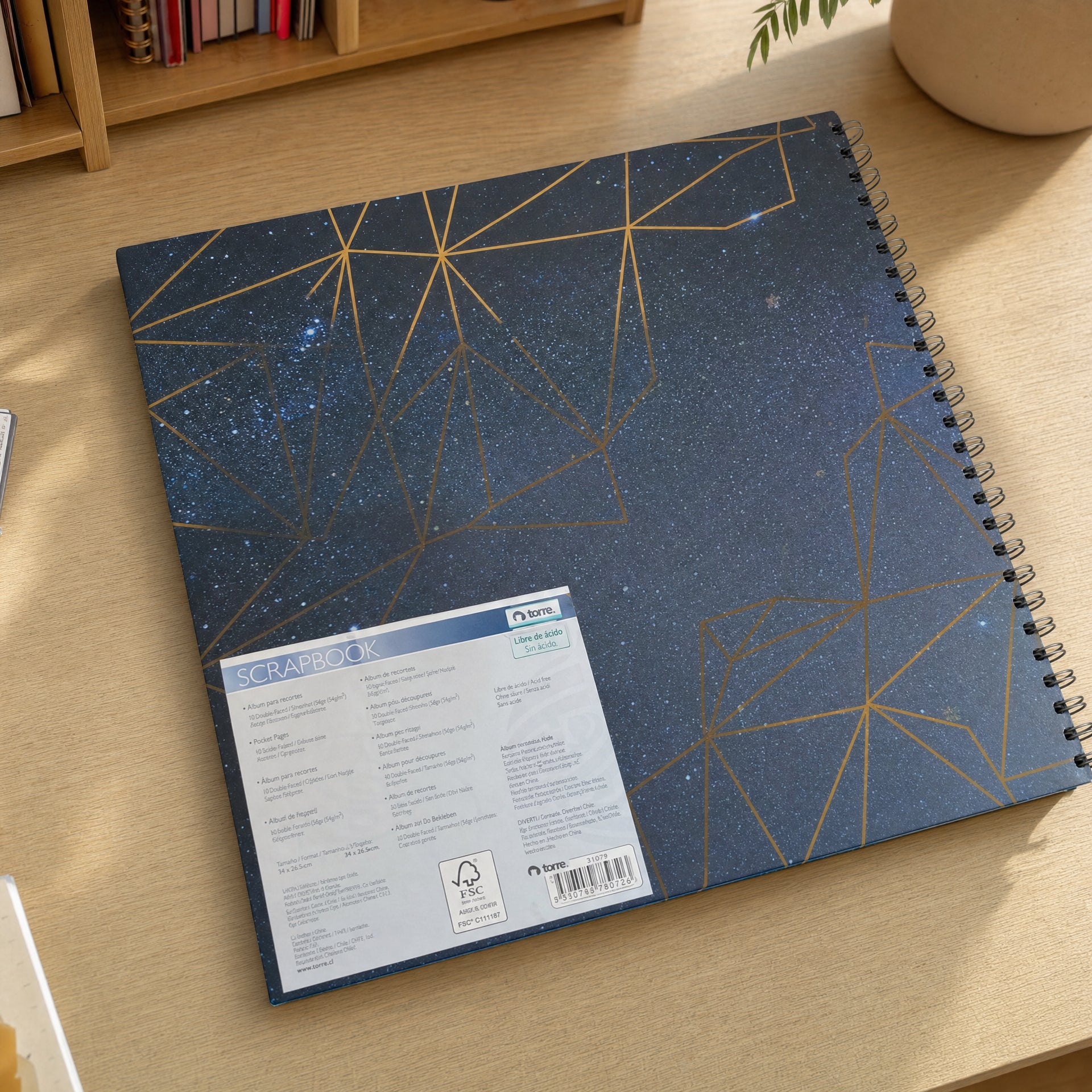 Álbum encuadernado en espiral azul oscuro con líneas geométricas doradas y puntos estelares