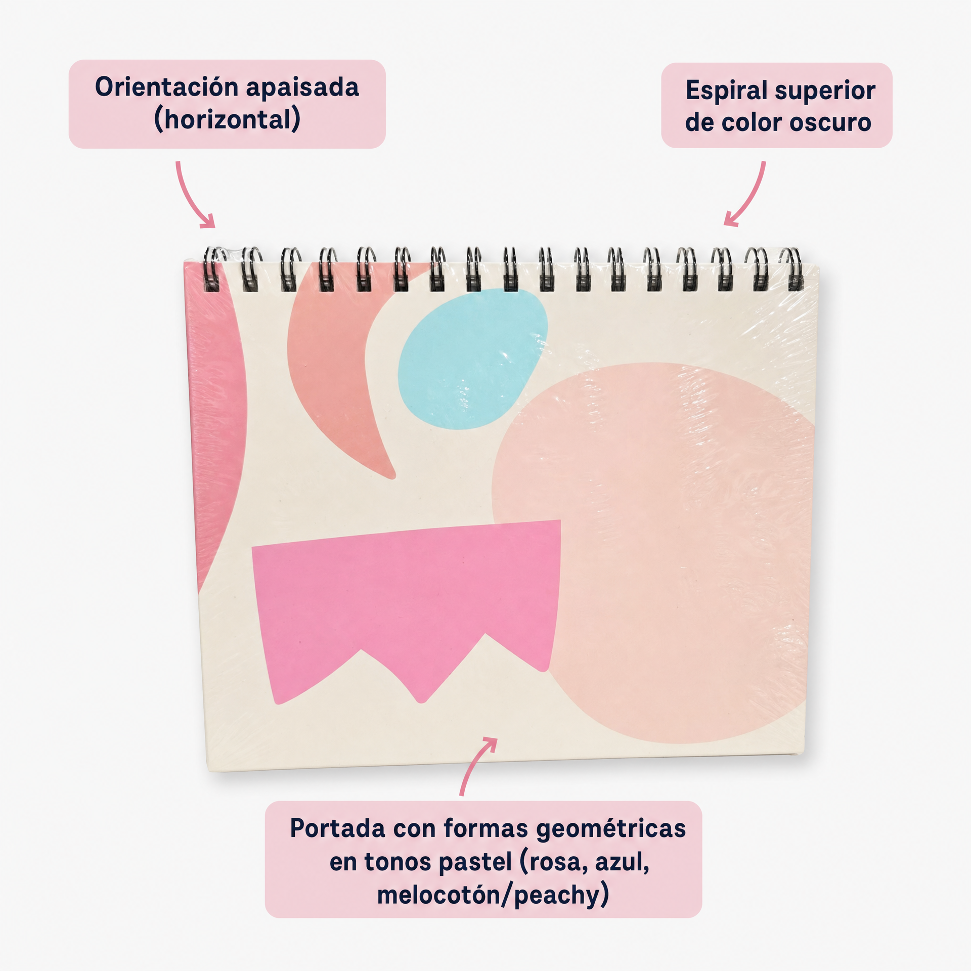Cuaderno con espiral en el borde superior y portada geométrica rosa, azul y melocotón