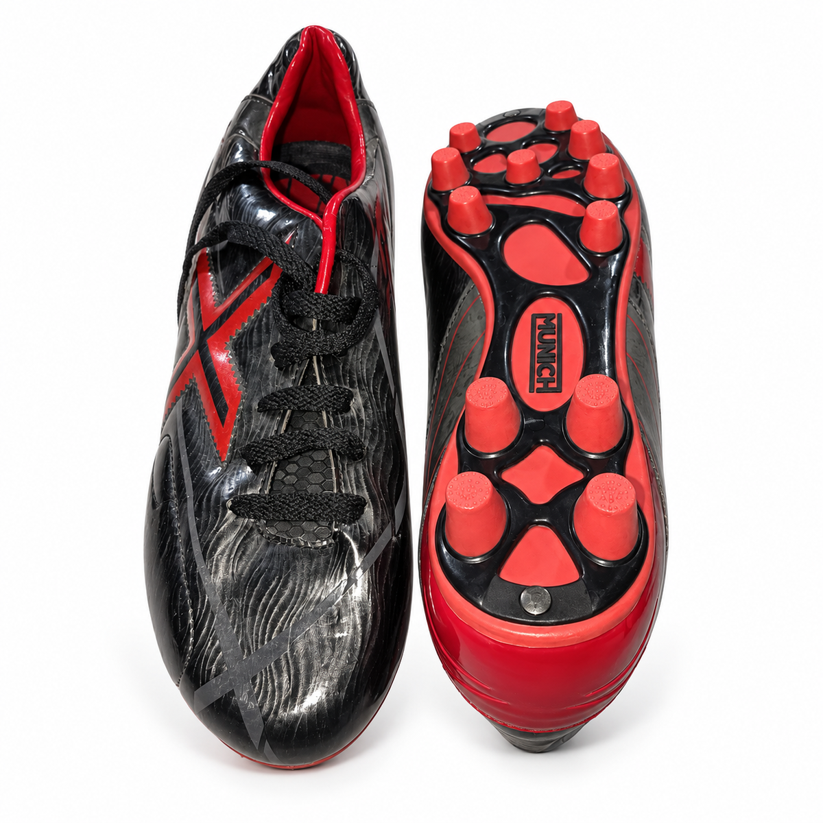 Botas de fútbol Munich negras con detalles rojos y tacos sobre fondo blanco