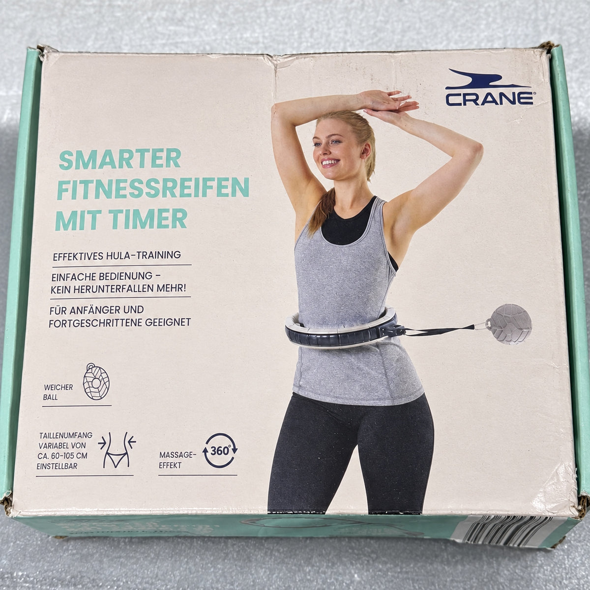 Caja CRANE de aro de fitness gris con temporizador; desgaste visible en el embalaje