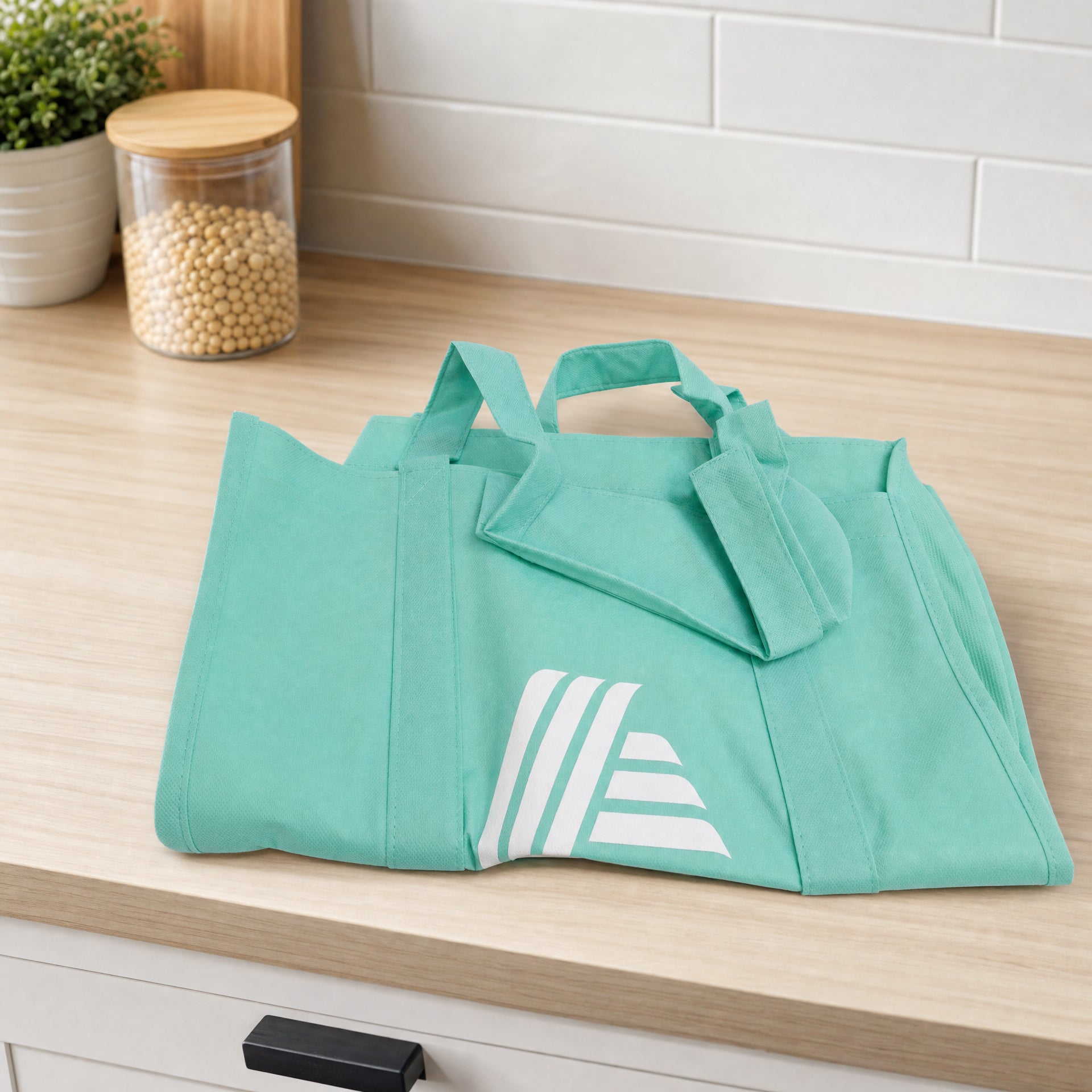 Bolsa de compra reutilizable verde con asas cortas y estampado blanco parcial en el frontal