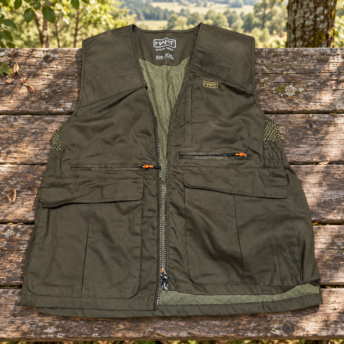 Chaleco Hart Maqueda-V verde oliva XXL sobre una mesa de madera junto al bosque