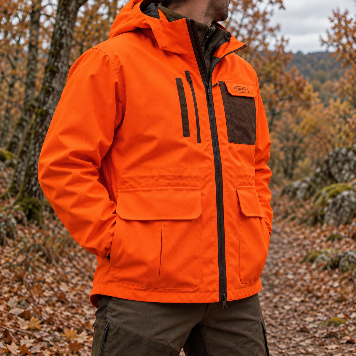 Chaqueta HART WILD-J naranja en un entorno de caza y bosque