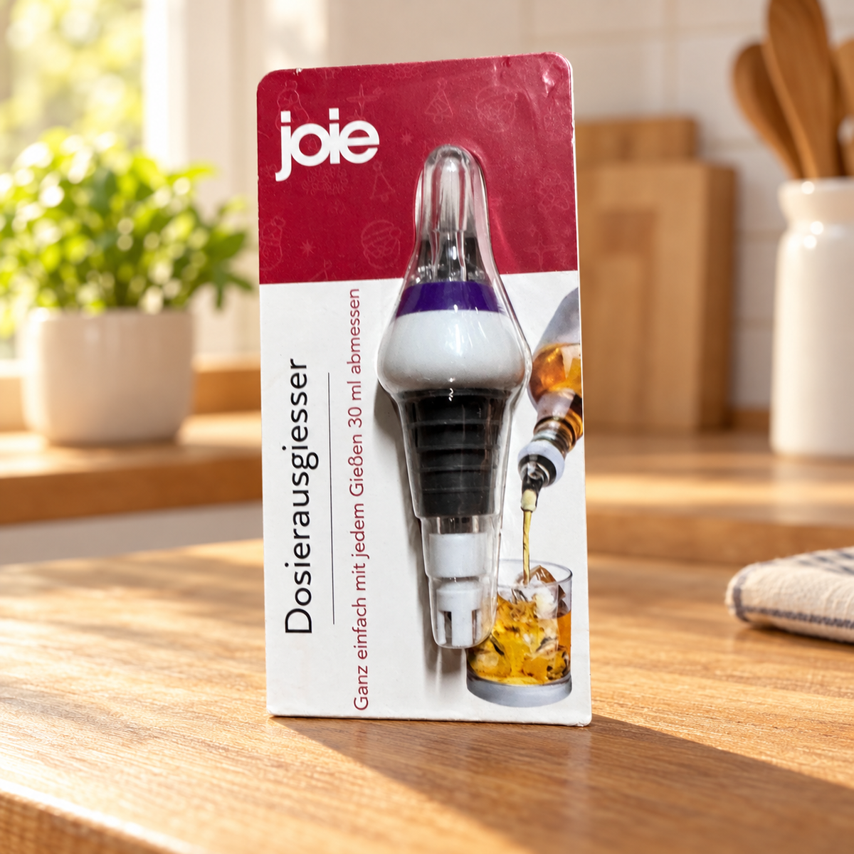 Dosificador Joie en su blíster original sobre una encimera de cocina