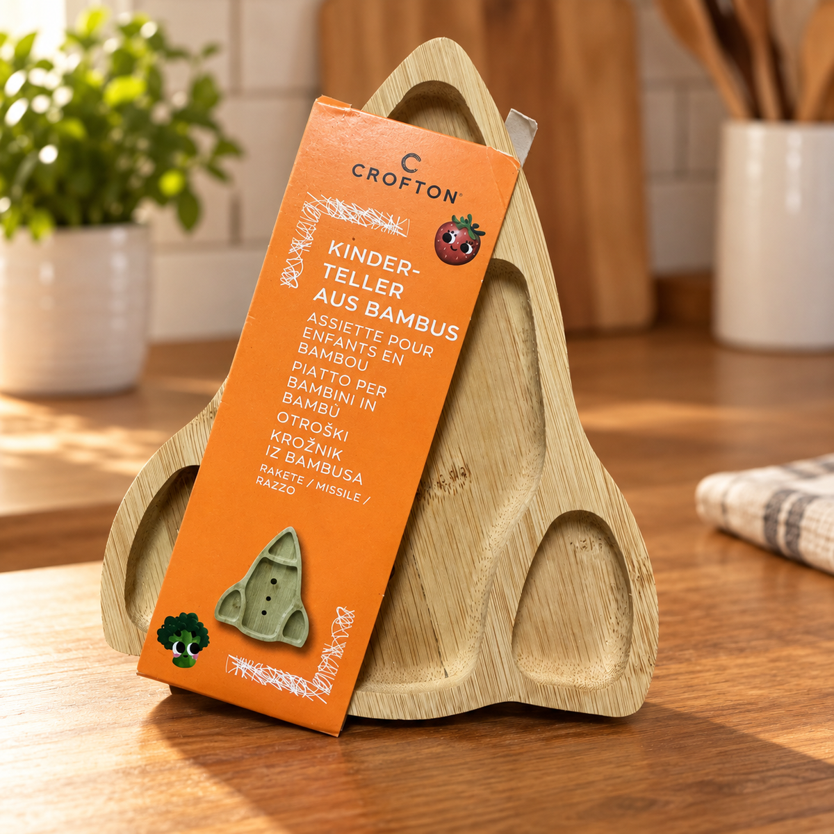 Crofton plato infantil de bambú con forma de cohete: producto con su embalaje original en ambiente de uso