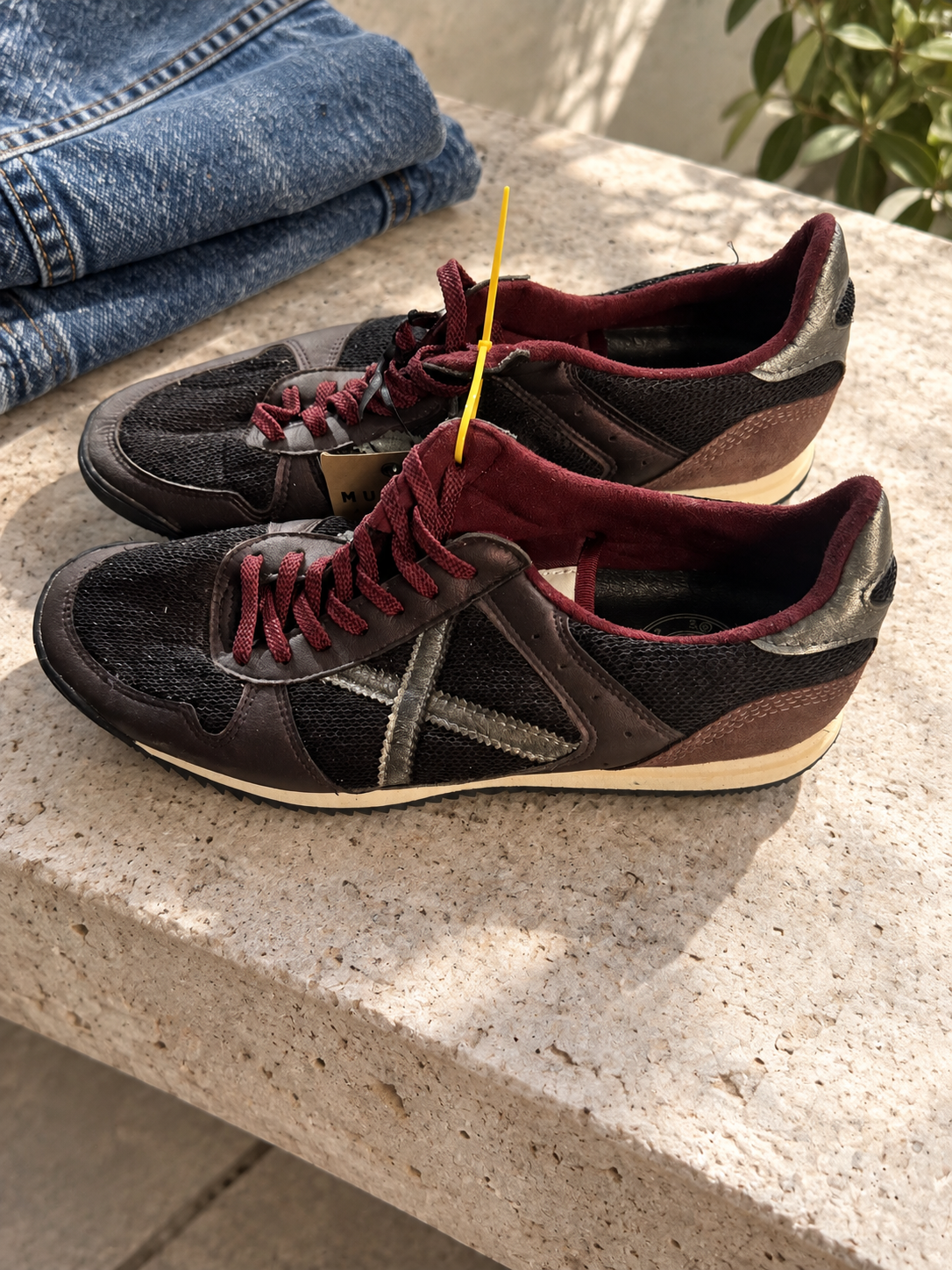Zapatillas Munich negras y burdeos con X plateada — escena con el par real