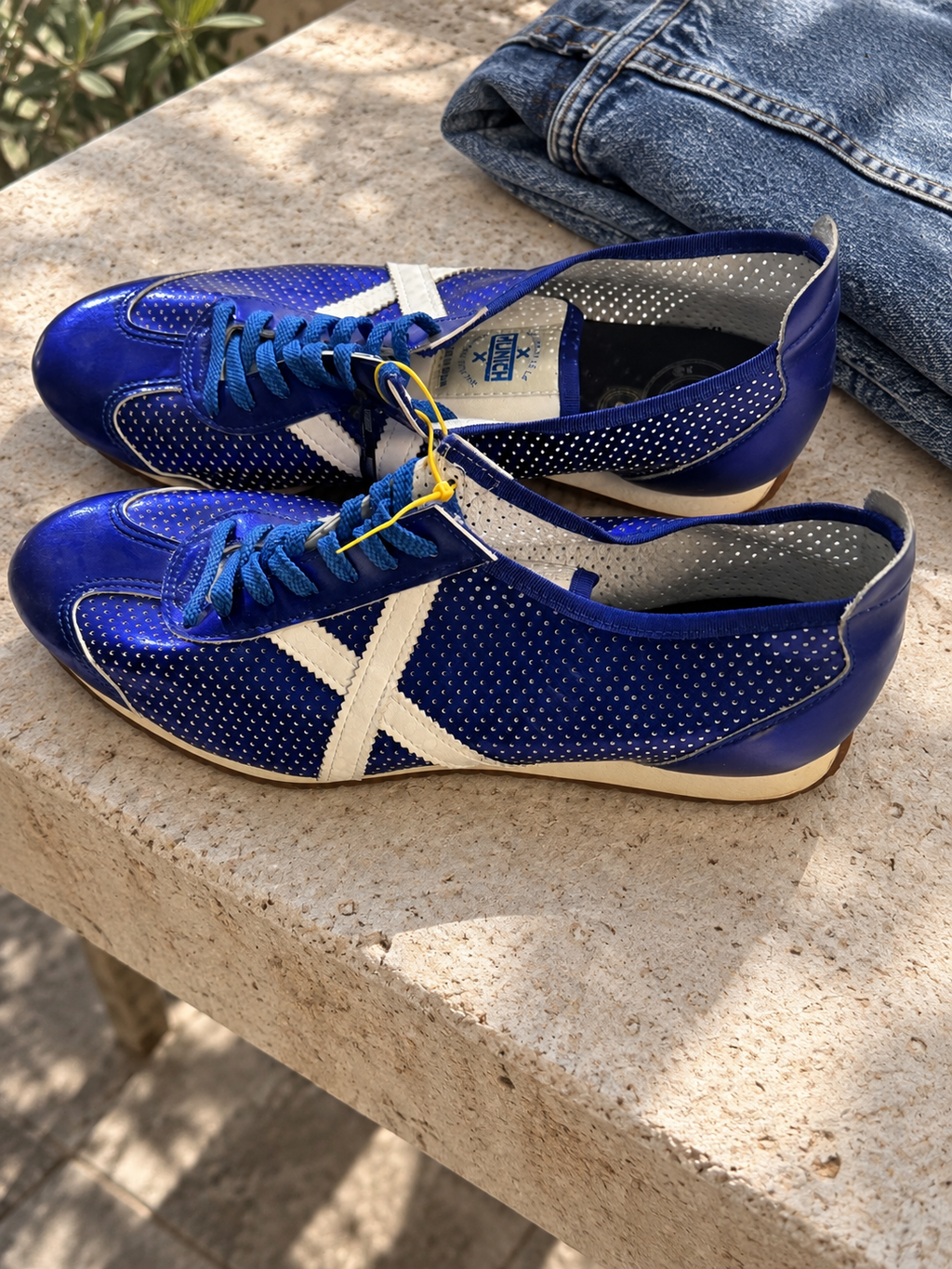 Zapatillas Munich azul eléctrico perforadas con X blanca — escena con el par real