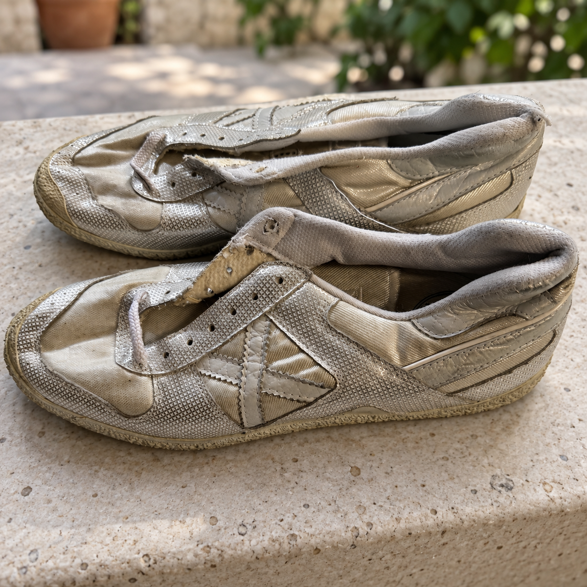 Zapatillas Munich plateadas y champán con textura geométrica — par en escena cotidiana