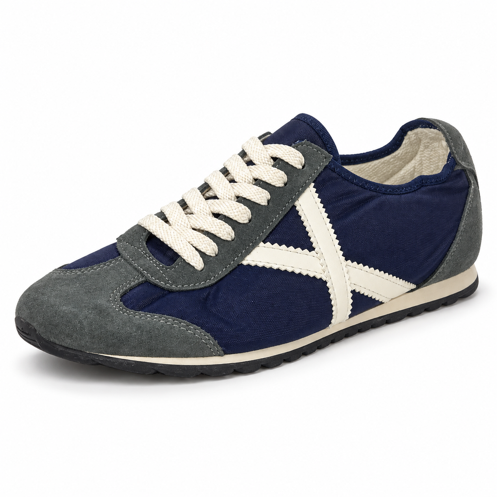 Zapatillas Munich azul marino y gris con detalles crema sobre fondo blanco