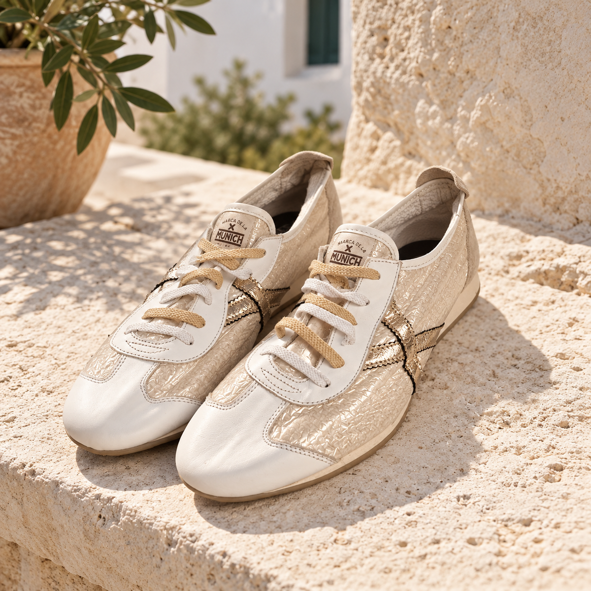 Zapatillas Munich blancas y perla dorada en ambiente mediterráneo