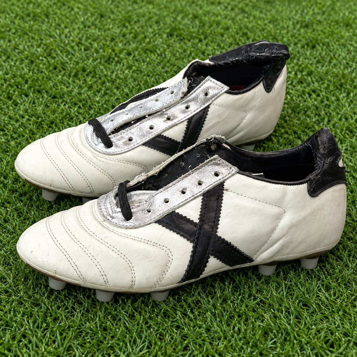 Botas Munich blancas X negra talla 40 junto a césped deportivo