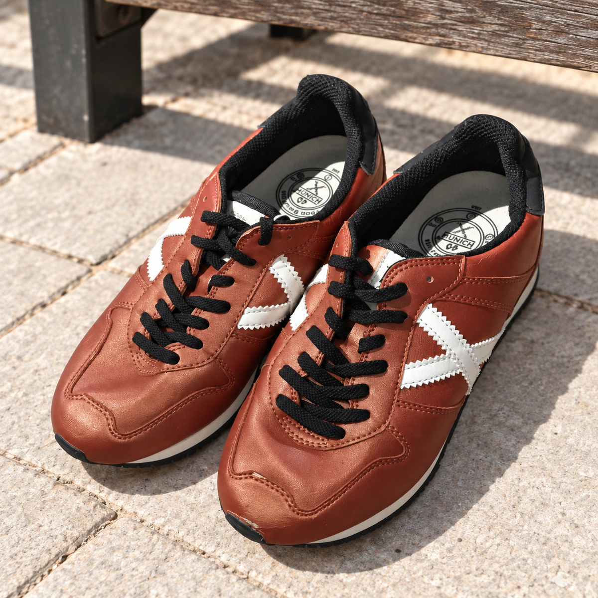 Munich cobre con X blanca talla 40 junto a banco urbano