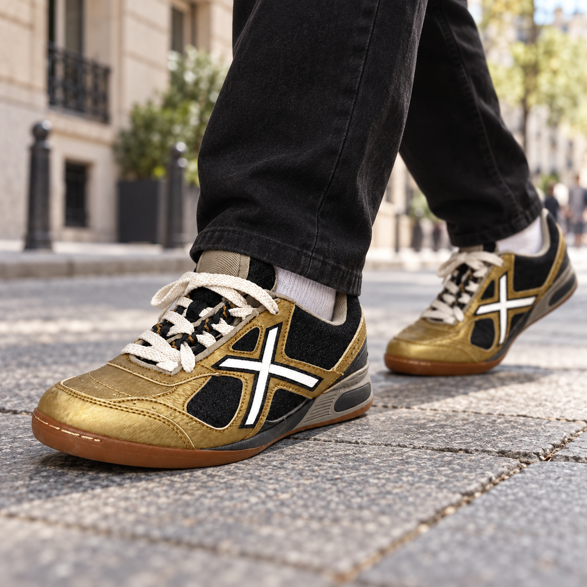 Zapatillas Munich doradas y negras en una escena urbana