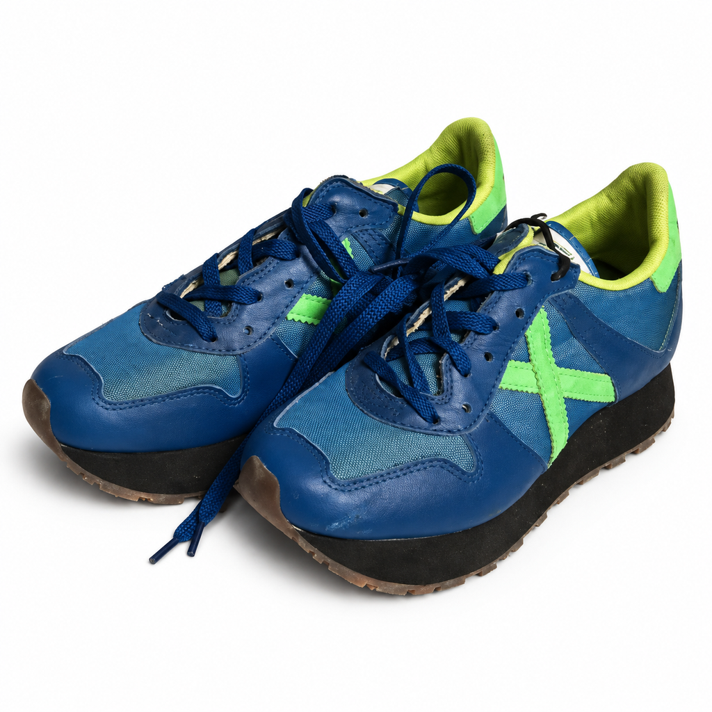 Zapatillas de fútbol Munich azules con detalles verde lima, vista principal sobre fondo blanco