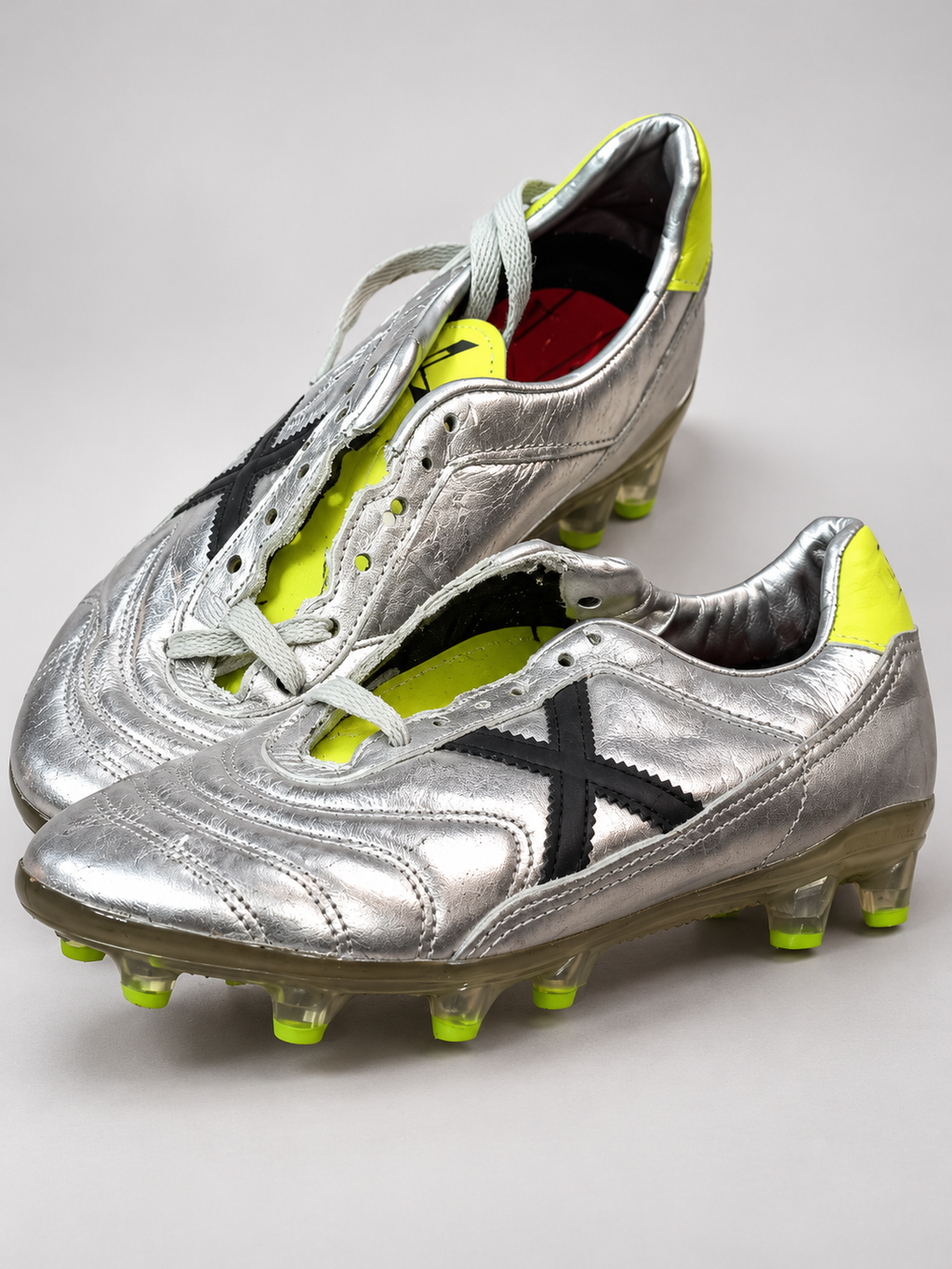 Botas fútbol Munich plateadas X negra tacos lima talla 40 detalle de puntera y cordones parciales