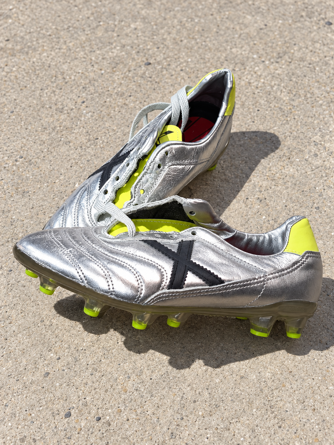 Botas fútbol Munich plateadas X negra tacos lima talla 40 sobre pavimento