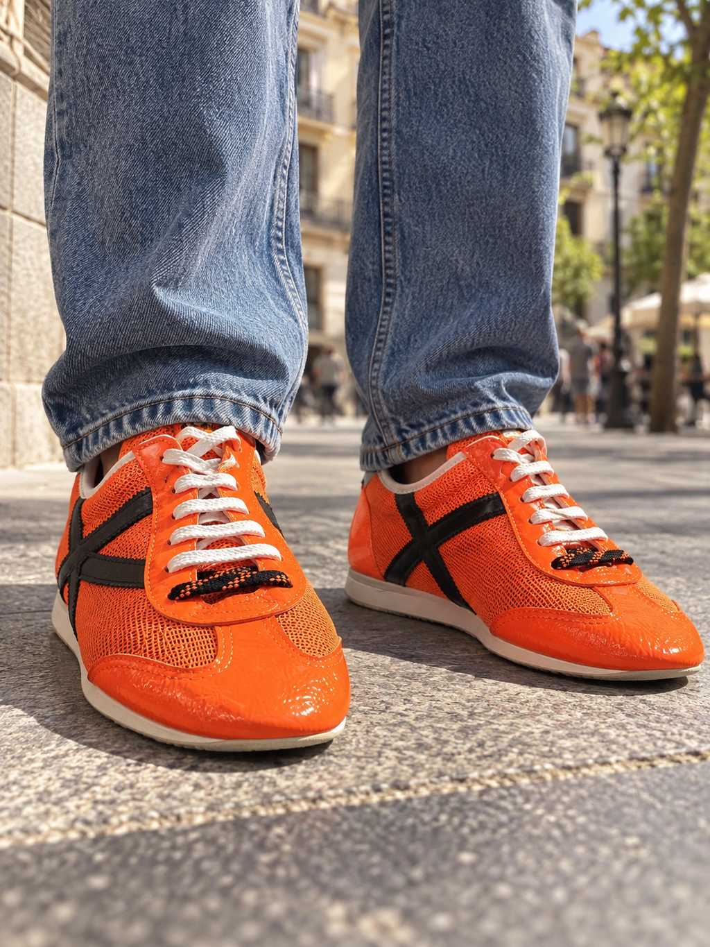 Zapatillas Munich naranjas de malla con detalles negros en escena lifestyle