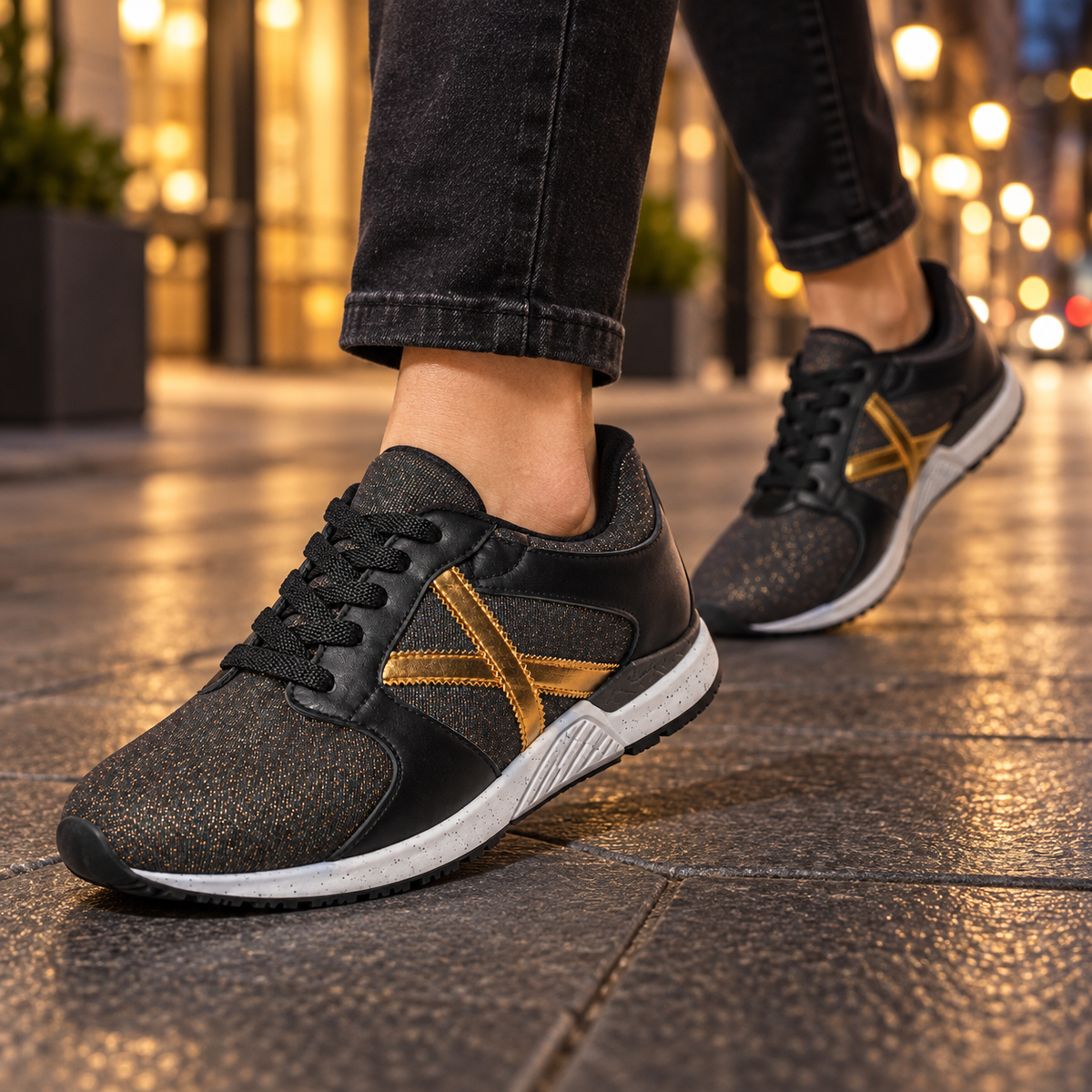 Zapatillas Munich negras con brillo y detalle dorado en ambiente urbano