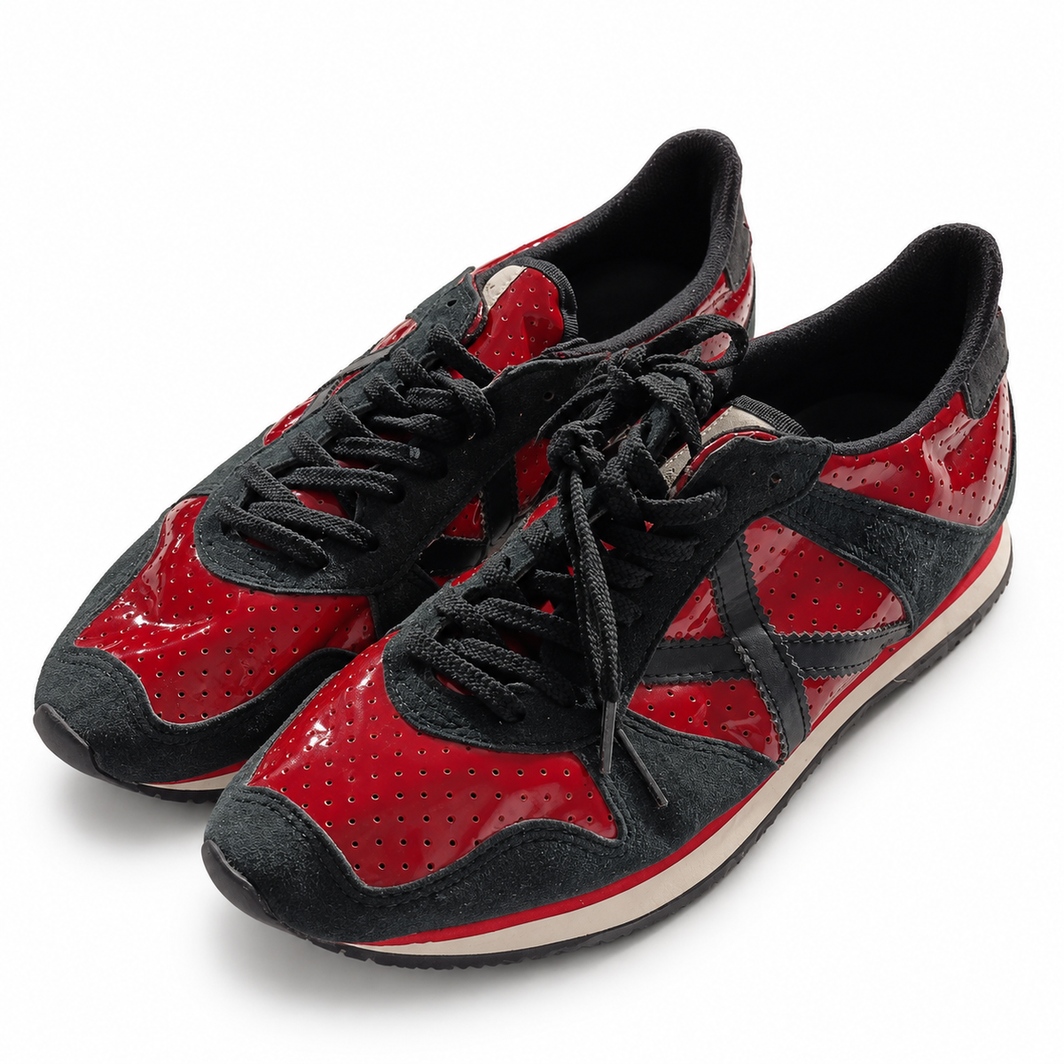 Zapatillas Munich rojas perforadas y negras sobre fondo blanco
