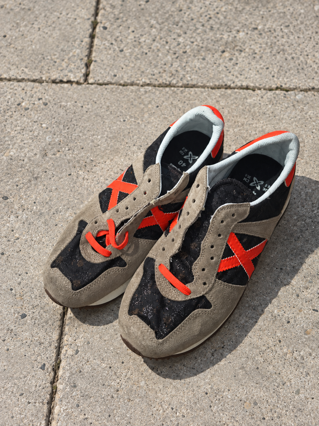 Munich taupe negras X naranja talla40 sobre pavimento