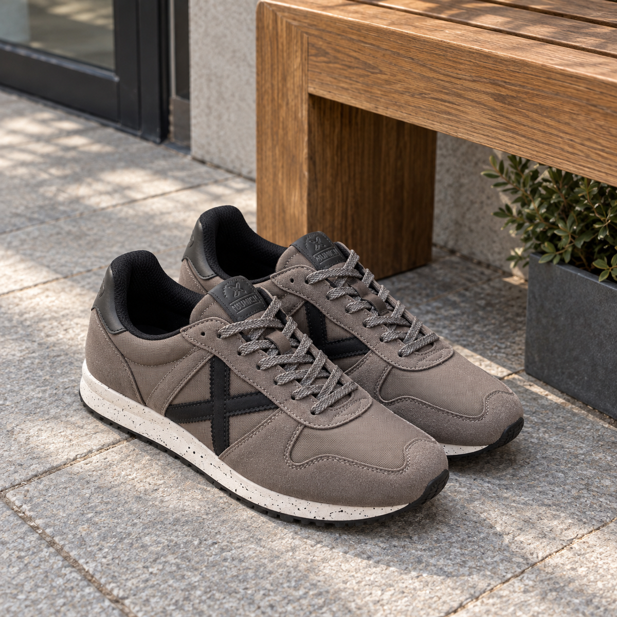 Zapatillas Munich gris topo con X negra en ambiente lifestyle