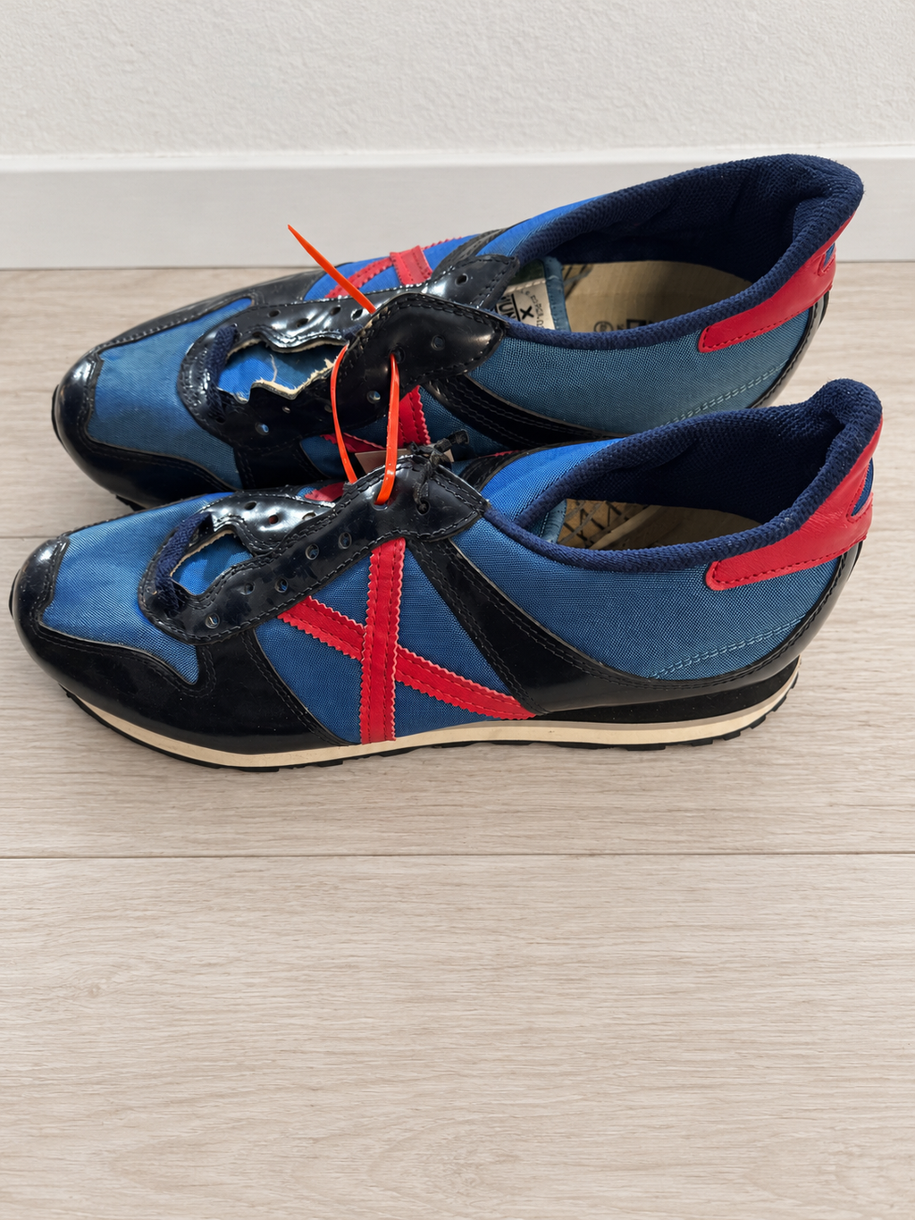 Munich azul y negro con X roja talla 45, sin cordones y con desgaste visible — ambiente
