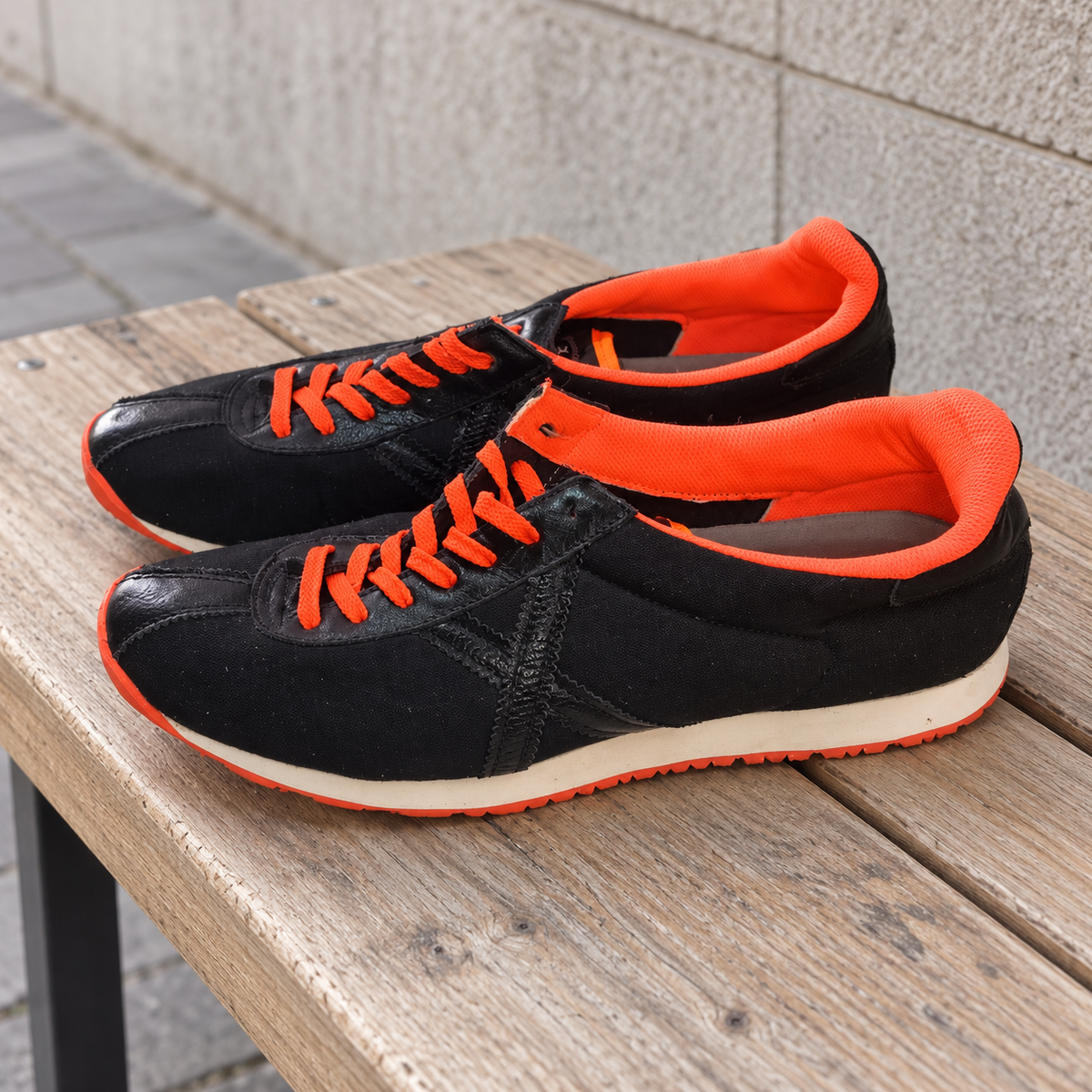 Zapatillas Munich negras con X tonal y cordones naranja · Talla 45 - lifestyle sobre banco