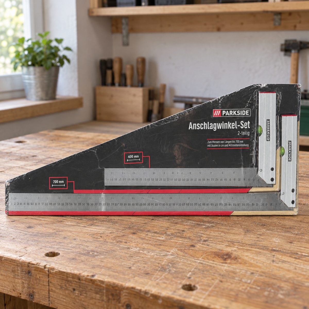 Un juego Parkside de dos escuadras de 400 y 700 mm en su embalaje sobre una mesa de taller