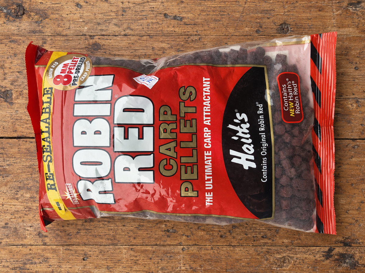 Bolsa Dynamite Robin Red pellets preperforados 8 mm sobre mesa de madera