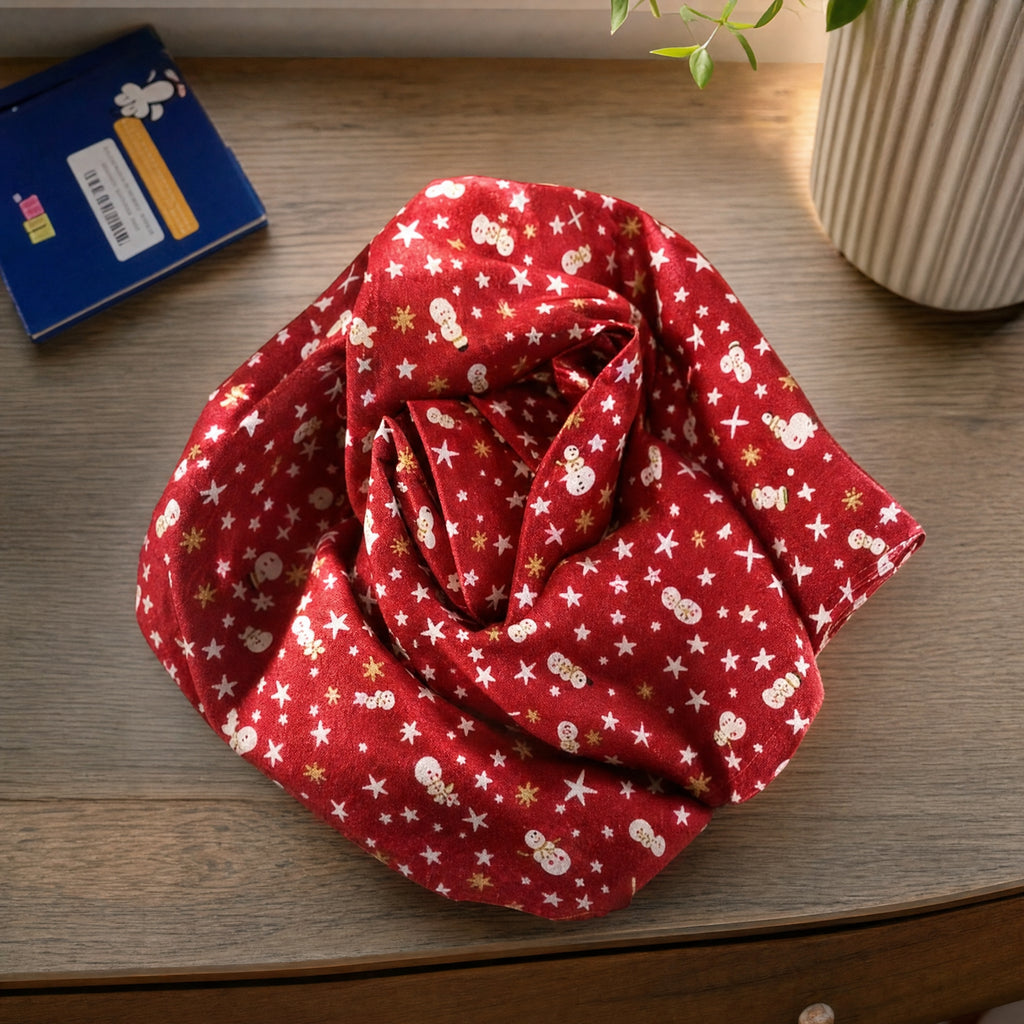 Retal de tela con fondo rojo y estampado de muñecos de nieve y estrellas en blanco y dorado