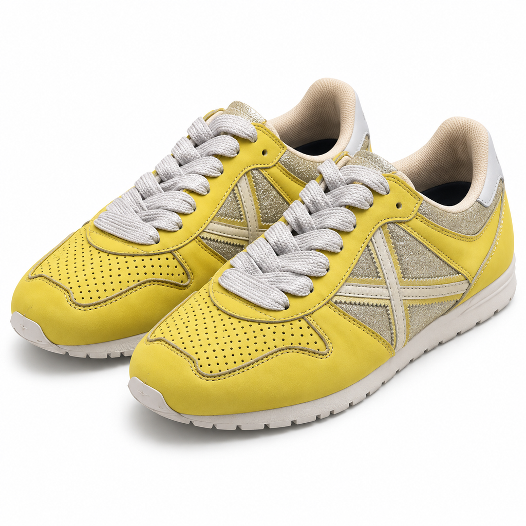 Zapatillas Munich amarillas y plateadas sobre fondo blanco