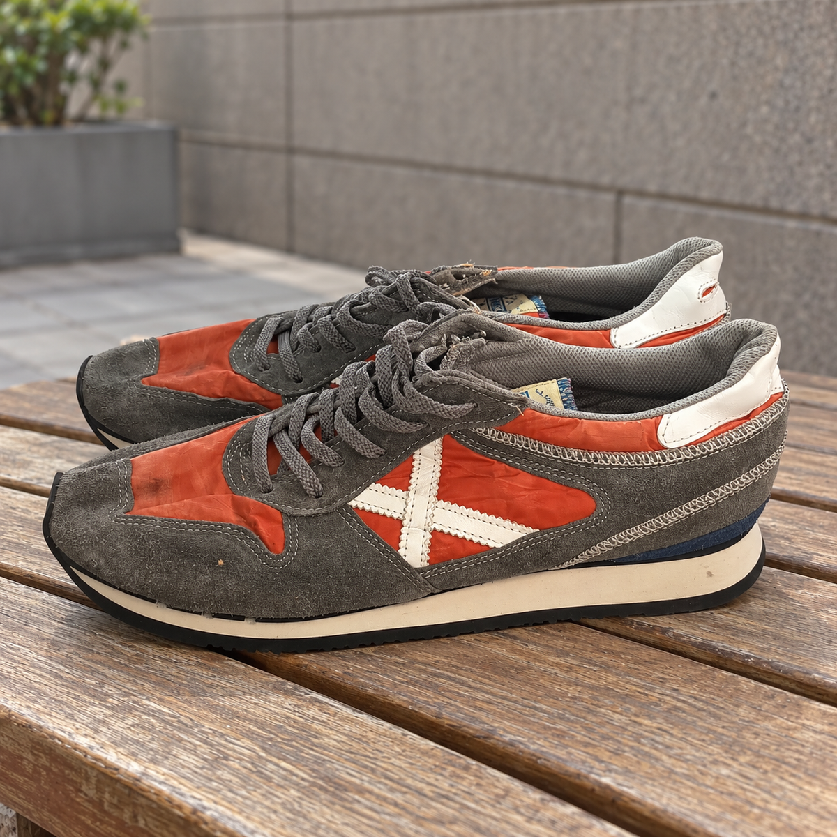 Zapatillas Munich naranjas y grises con X blanca · Talla 45 - lifestyle sobre banco