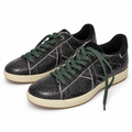 Zapatillas Munich negras con acabado cuarteado y cordones verdes sobre fondo blanco