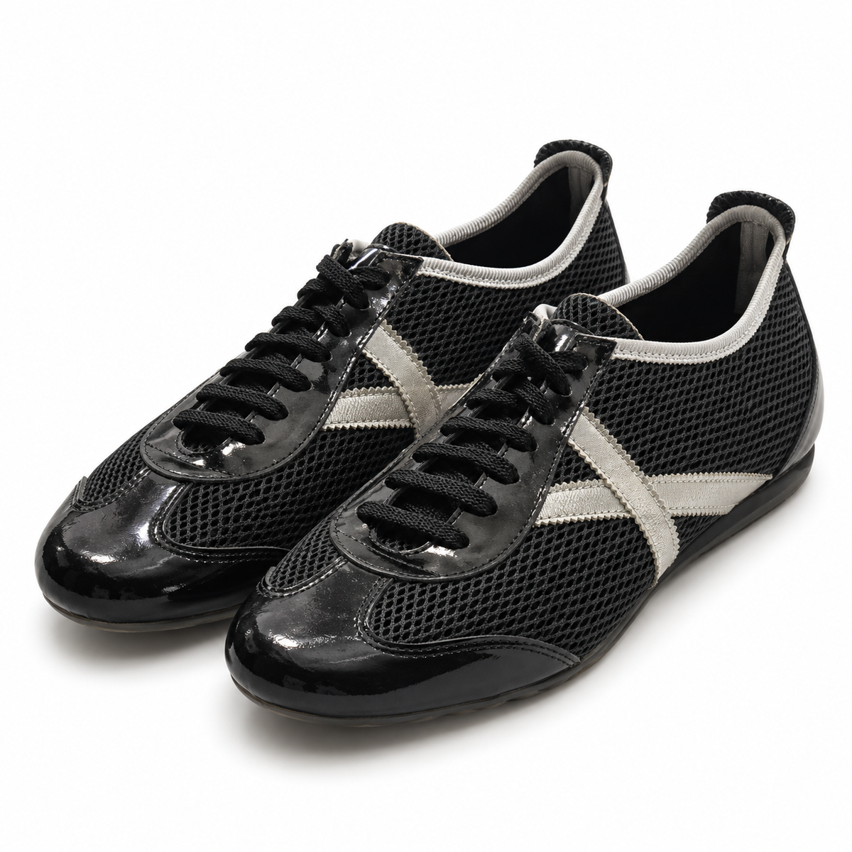 Zapatillas Munich negras de malla con detalles plateados sobre fondo blanco